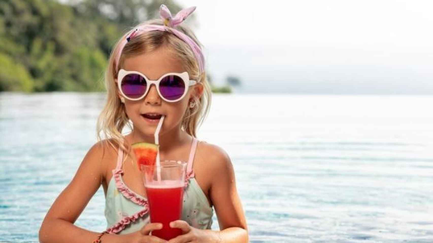 Niña en una piscina tomando algo