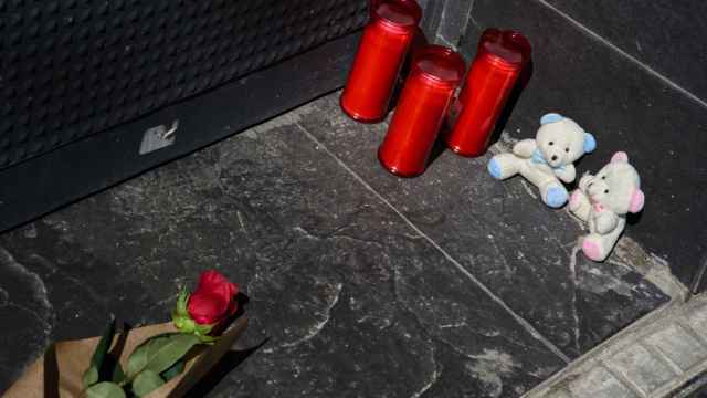 Una rosa, tres velas y dos osos de peluche en la puerta del garaje de la vivienda donde un hombre ha matado presuntamente a su mujer y sus dos hijos menores, 10 de abril de 2024, en El Prat de Llobregat, Barcelona