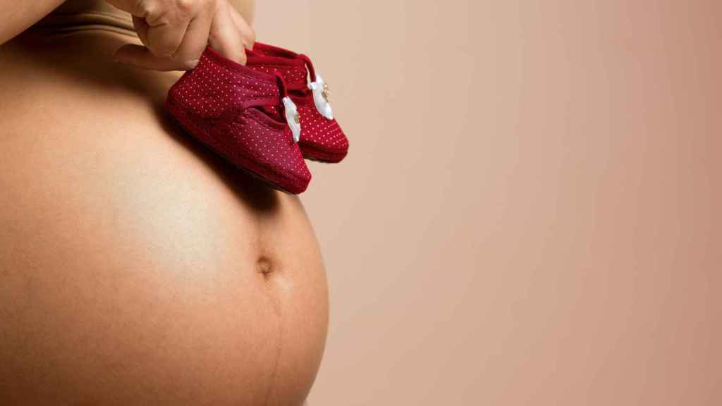 Mujer embarazada con patucos