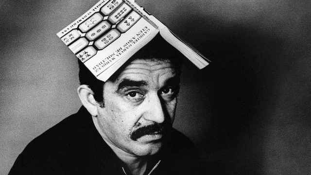 Gabriel García Márquez retratado por Colita con un libro por sombrero