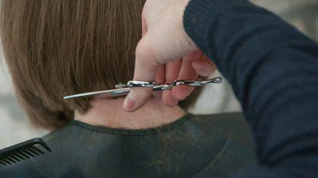 Un peluquero corta el pelo a una clienta, en una imagen de archivo