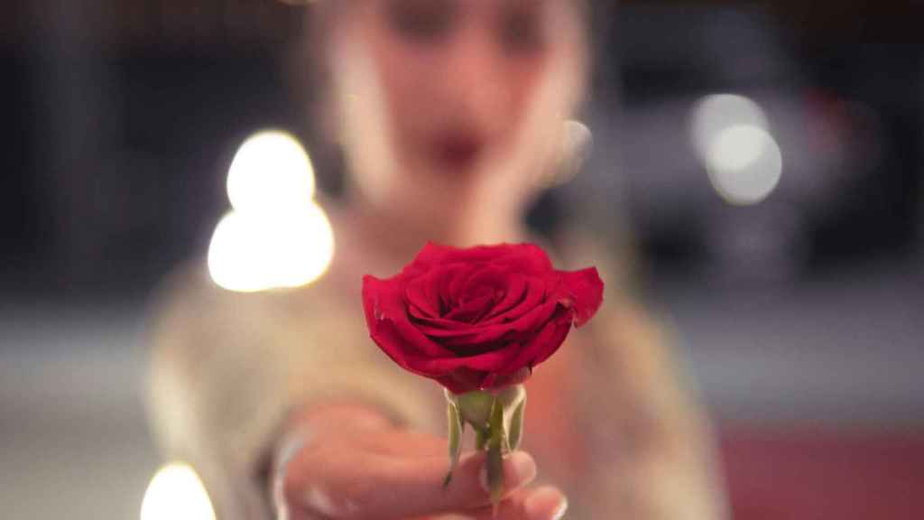 Una mujer dando una rosa