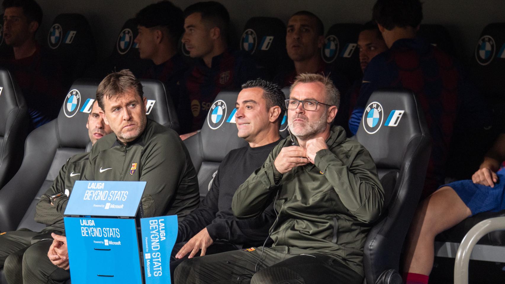 Xavi Hernández, junto a sus asistentes, en el banquillo del Bernabéu