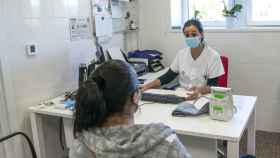 Una trabajadora sanitaria atiende a una paciente en el CAP Masdevall el día en el que comienza la campaña de vacunación antigripal en la región, en Figueres, Girona