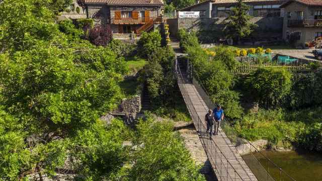 Dos personas pasean por un puente colgante