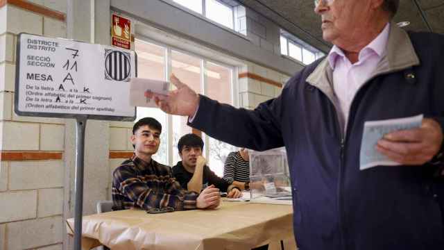 Los jóvenes de 19 años Antonio (i) y José (c) participan como vocales en el Centro Cívico de Sant Pere i Sant Pau de Tarragona, en las elecciones del 12M