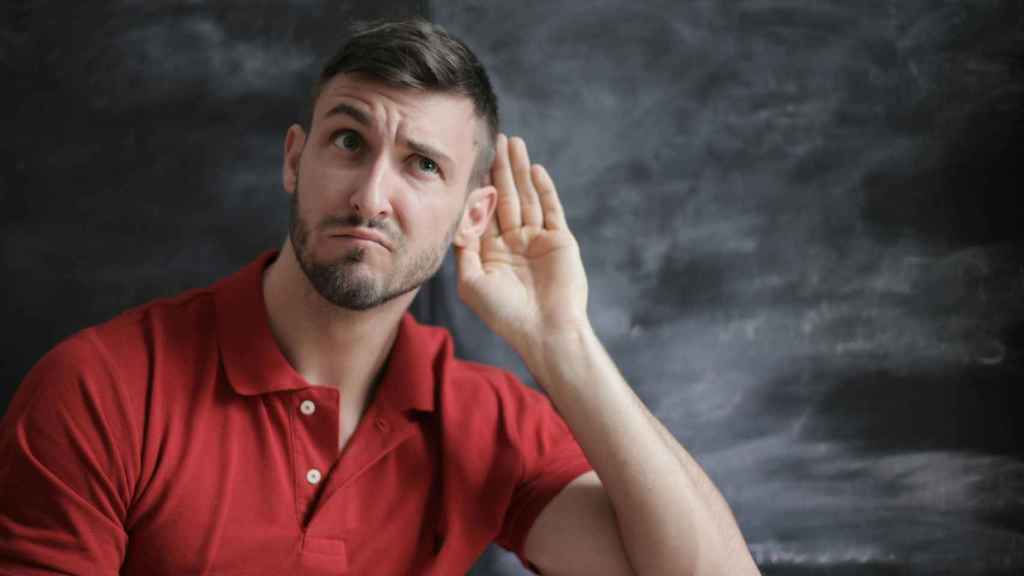 Un hombre pone la oreja para escuchar algo