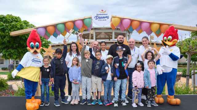 Voluntarios y niños acompañados de las mascotas de PortAventura en la inauguración de PortAventura Dreams Village