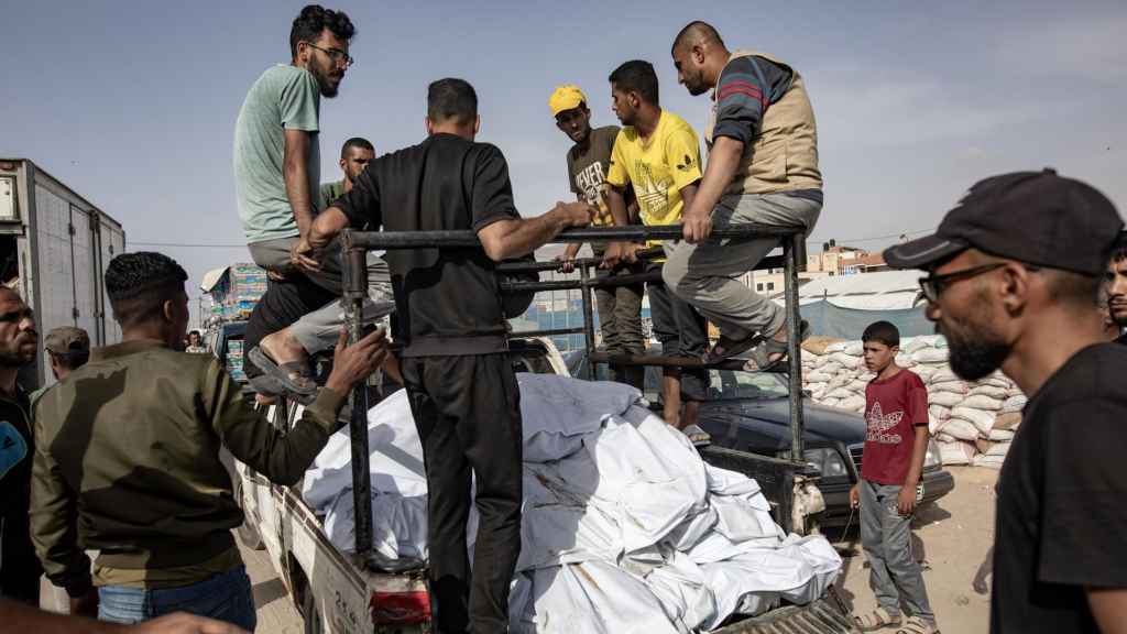 Un grupo de palestino transporta cadáveres tras un ataque de Israel en Rafah