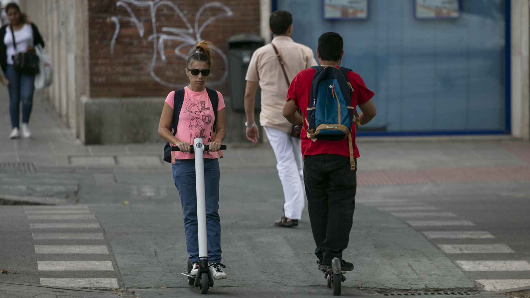 Dos personas en patinete eléctrico