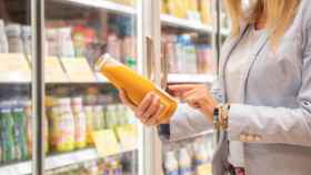 Una mujer mira la etiqueta de un producto en el supermercado