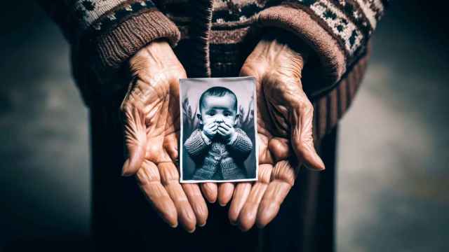 Imagen generada por IA de las manos de una madre con una imagen de su hijo