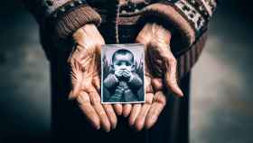 Imagen generada por IA de las manos de una madre con una imagen de su hijo