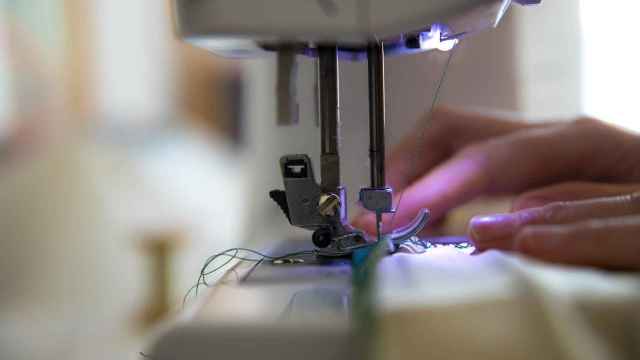 Una mujer utiliza una máquina de coser