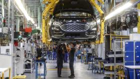 Dos trabajadores con un vehículo de la fábrica de Ford en Almussafes, a 24 de octubre de 2022