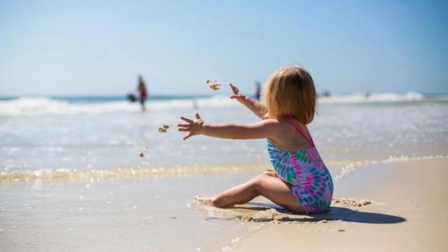 Una niña jugando en la arena | PEXELS