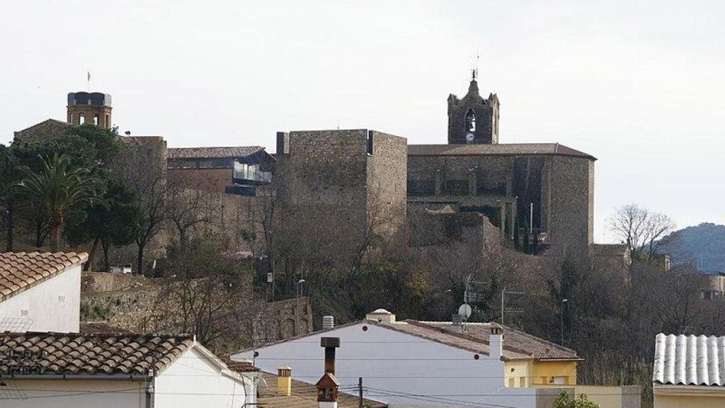 La torre cuadrada del castillo (primer plano) y la iglesia de Calonge