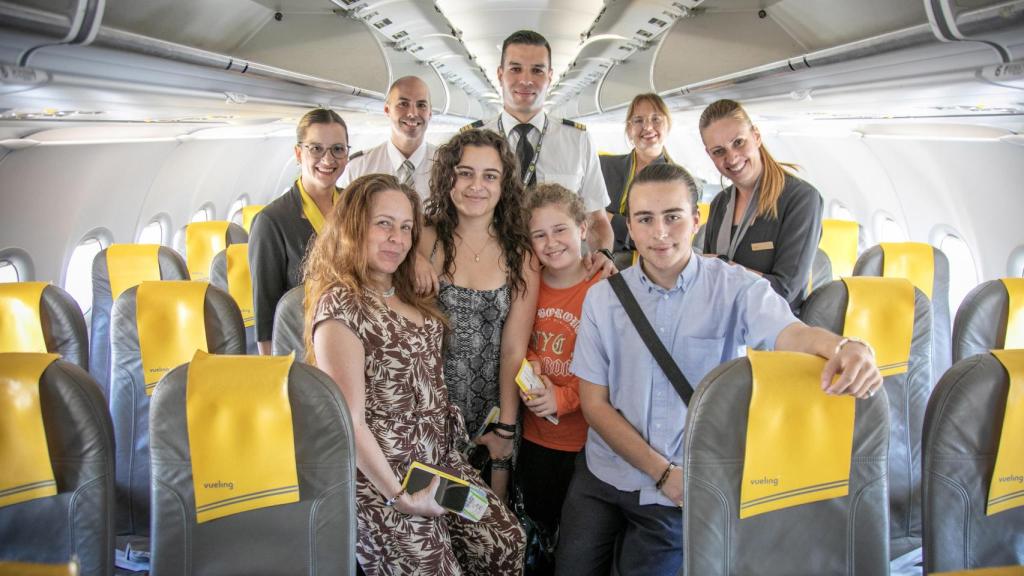 La tripulación de un avión de Vueling posa con un grupo de niños y niñas