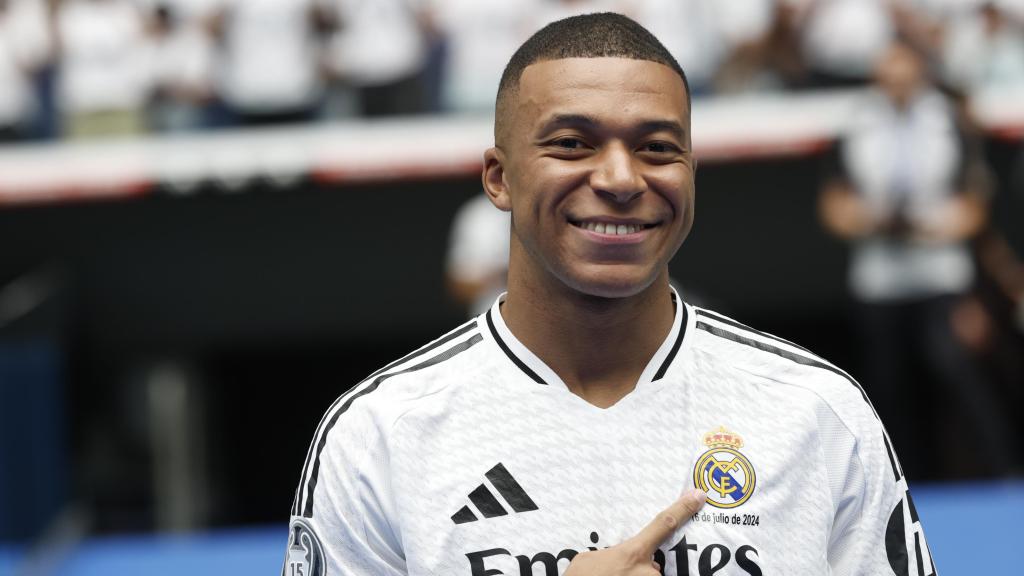 Kylian Mbappé se señala el escudo en su presentación con el Real Madrid