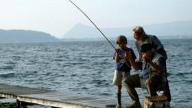 Un abuelo y su nieto pescando | CANVA