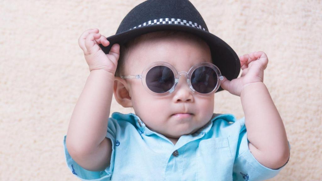 Un niño con gafas de sol y un sombrero