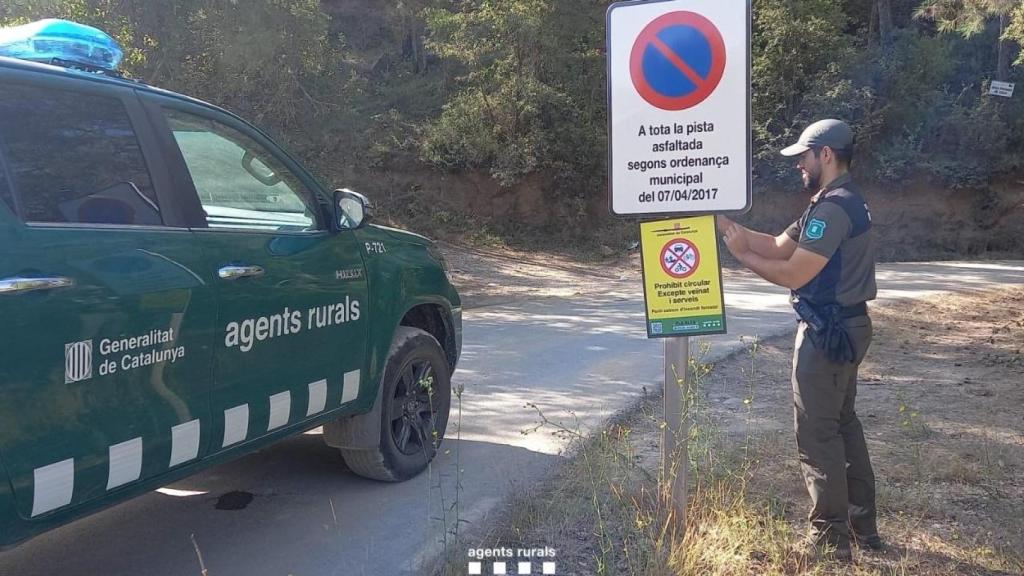 Un agente rural coloca una señal para restringir el acceso a una zona en elevado riesgo de incendio