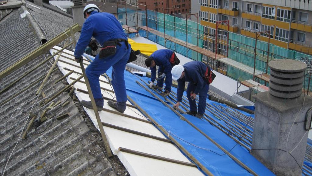 Varios trabajadores en el tejado de un edificio