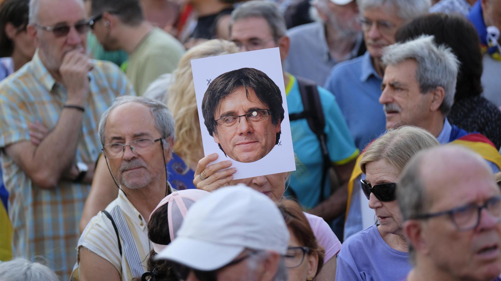 Una persona sostiene una careta de Carles Puigdemont durante su reaparición en Barcelona