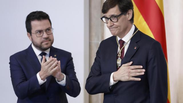 El nuevo 'president' de la Generalitat, Salvador Illa (derecha), recibe los aplausos de su predecesor, Pere Aragonès (izquierda), en la toma de posesión