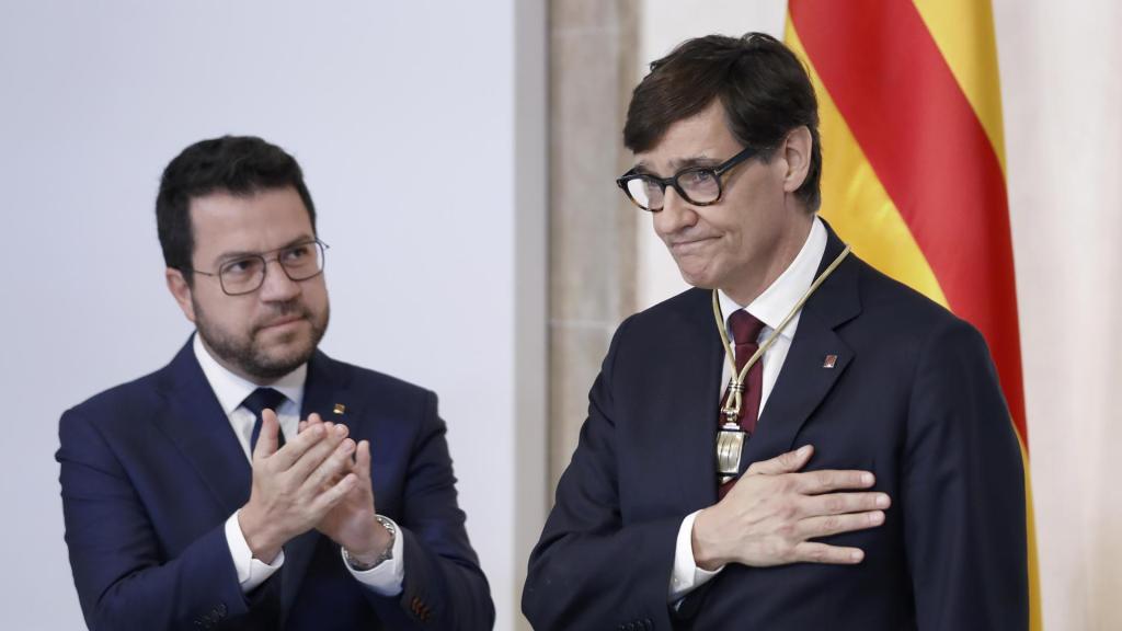 El nuevo 'president' de la Generalitat, Salvador Illa (derecha), recibe los aplausos de su predecesor, Pere Aragonès (izquierda), en la toma de posesión