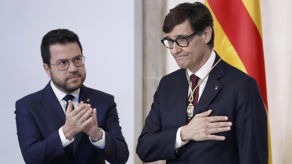 El nuevo 'president' de la Generalitat, Salvador Illa (derecha), recibe los aplausos de su predecesor, Pere Aragonès (izquierda), en la toma de posesión