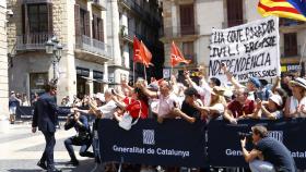 Salvador Illa, nuevo presidente de la Generalitat, se acerca a decenas de seguidores, con un grupo de detractores independentistas detrás