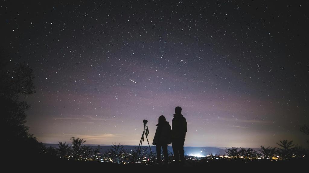 Gente mirando por un telescopio el cielo estrellado