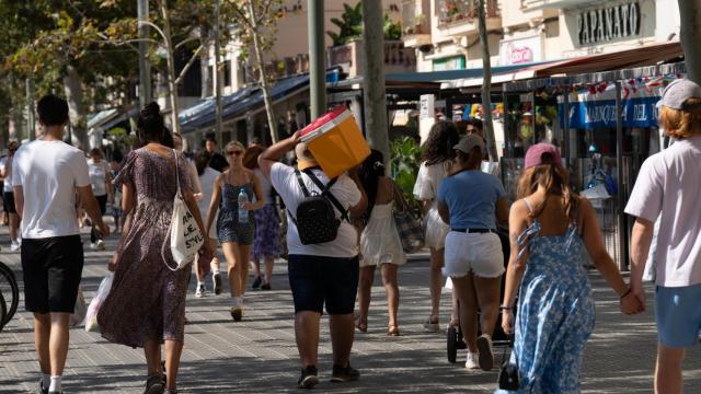 Varias personas pasean por Barcelona en un día de calor