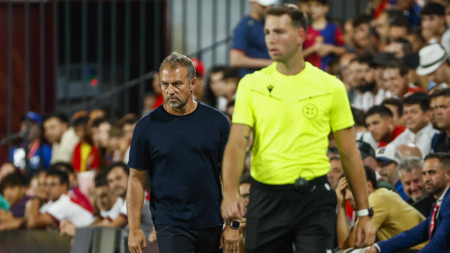 César Soto Grado, delante de Hansi Flick durante el Rayo-Barça