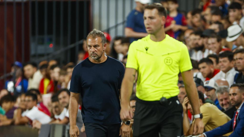 César Soto Grado, delante de Hansi Flick durante el Rayo-Barça