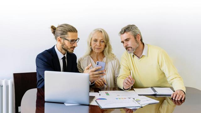 Un profesional instruye a dos personas sobre finanzas