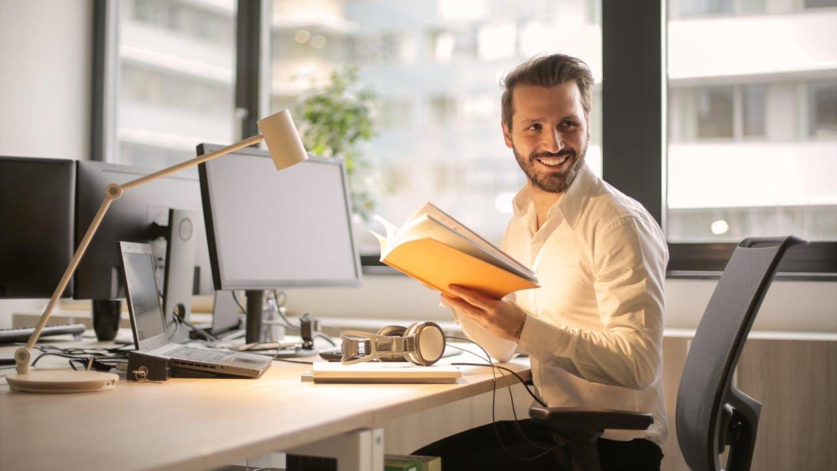 Empresario sonríe en su puesto de trabajo