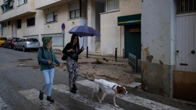 Dos mujeres pasean, una con paraguas, bajo la lluvia en Arenys de Mar (Barcelona)