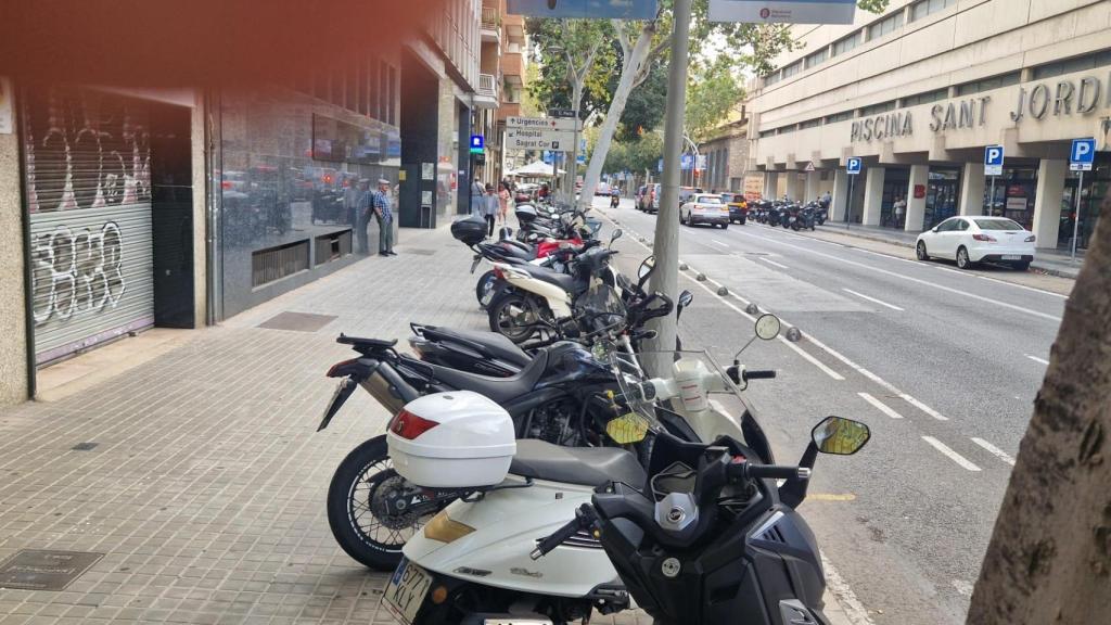 Motocicletas mal estacionadas en la acera de la calle París de Barcelona