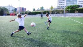 Dos niños juegan a futbol