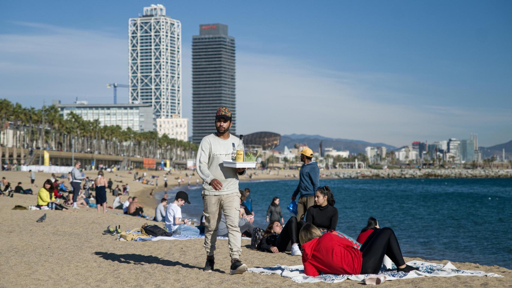 Personas que disfrutan de la playa a pesar de la caída de las temperaturas