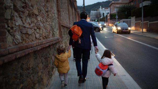 Un padre lleva a sus hijas al colegio en Barcelona