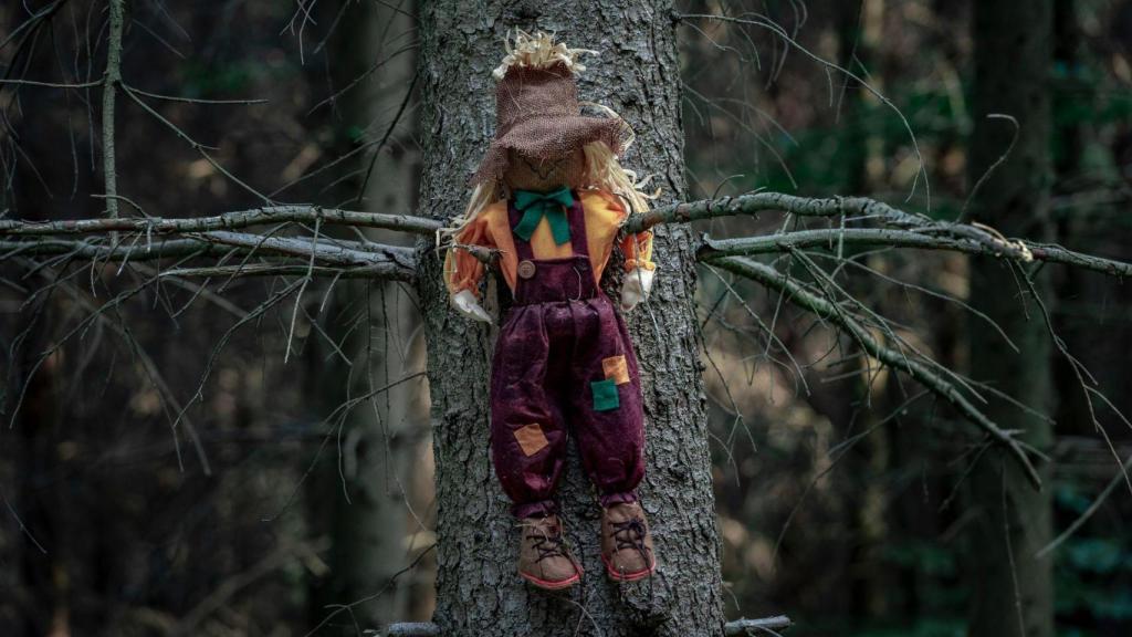 Un muñeco clavado en el árbol un bosque