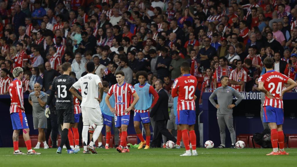 Los jugadores del Atlético y el Real Madrid, durante la interrupción del derbi por el lanzamiento de objetos