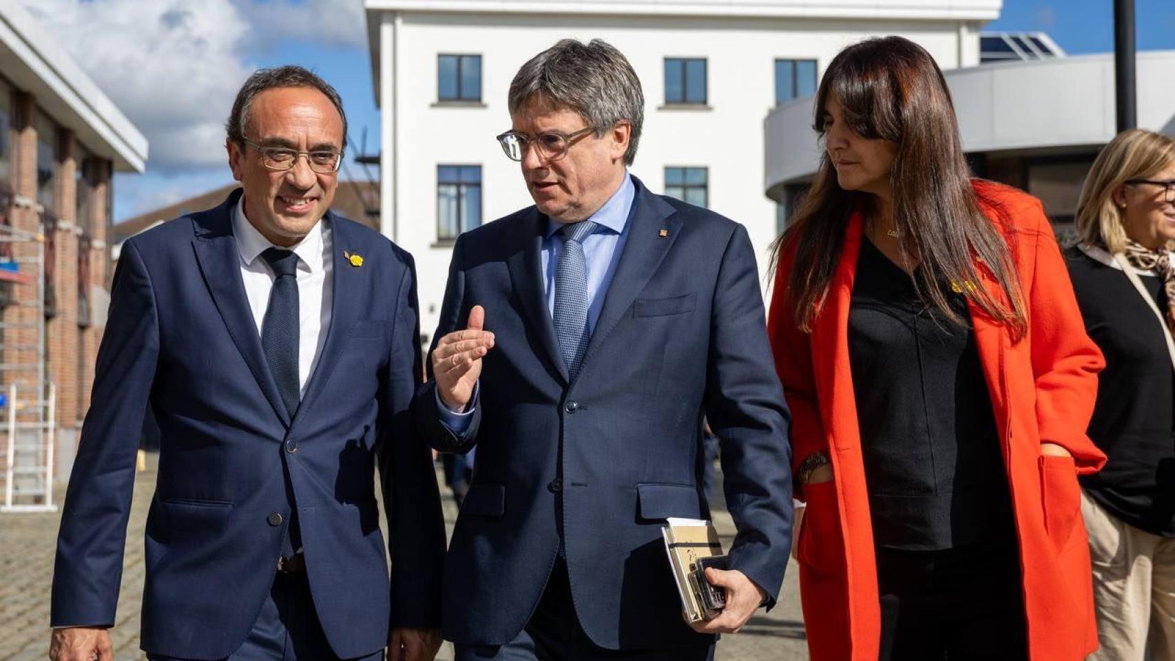 El presidente del Parlament, Josep Rull, el líder moral de Junts, Carles Puigdemont, y la presidenta del partido, Laura Borràs, en el séptimo aniversario del 1-O en Waterloo