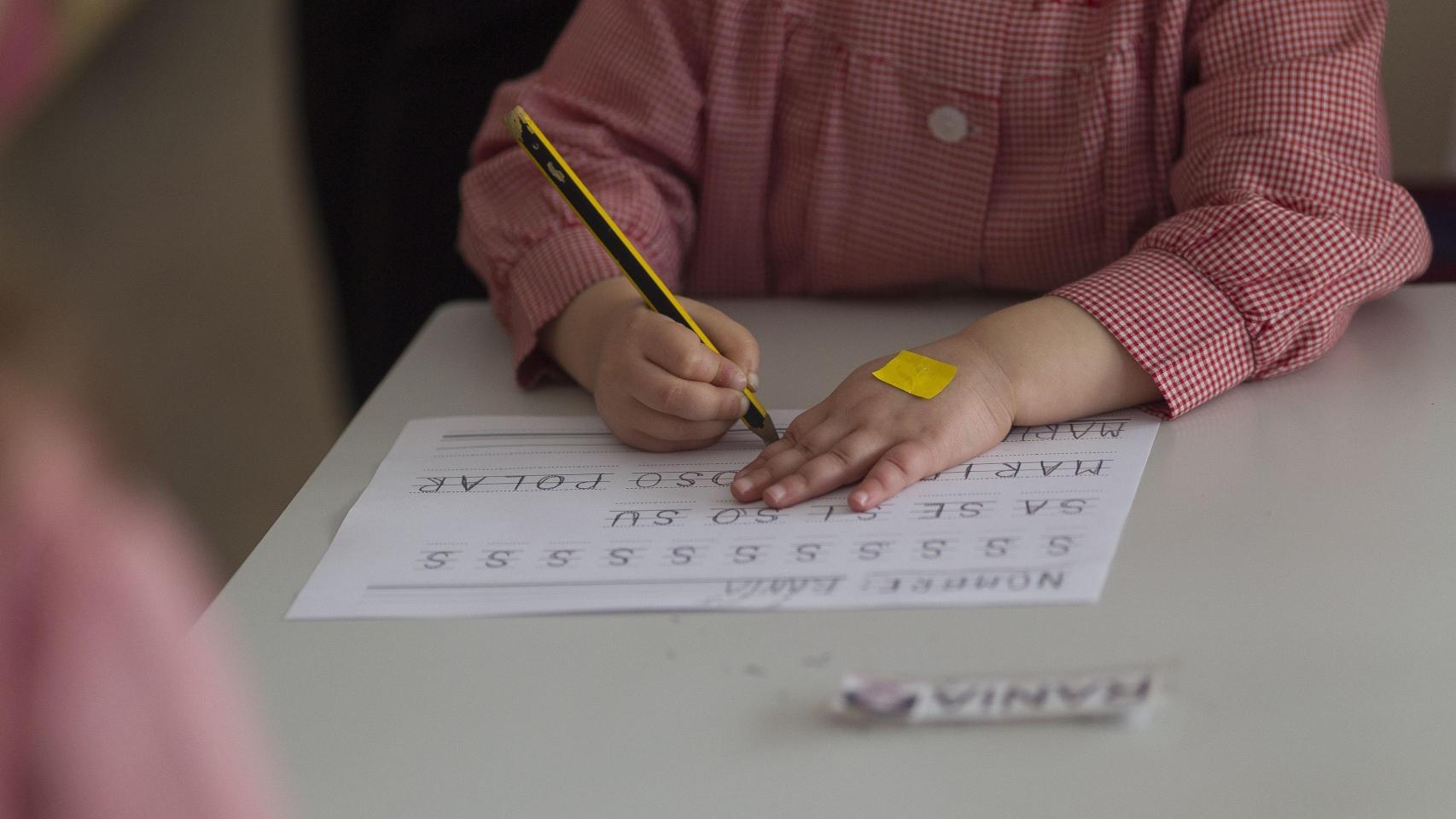 Un alumno de infantil aprende a escribir