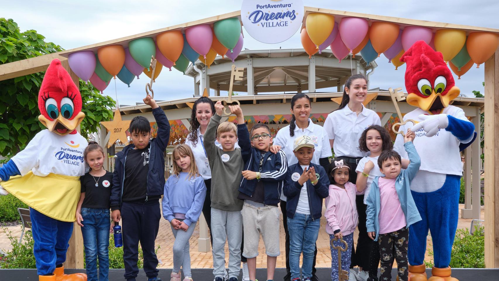 Voluntarios y niños, junto a las mascotas de PortAventura en el Dreams Village