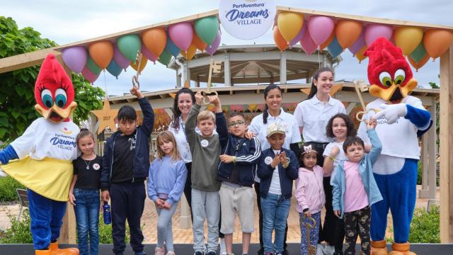 Voluntarios y niños, junto a las mascotas de PortAventura en el Dreams Village