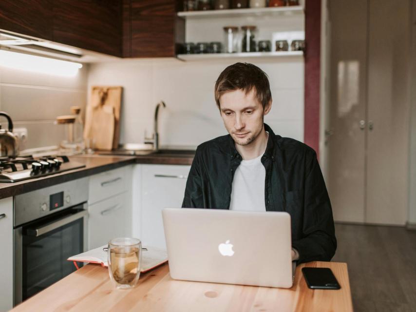 Un hombre trabaja desde la cocina de su casa